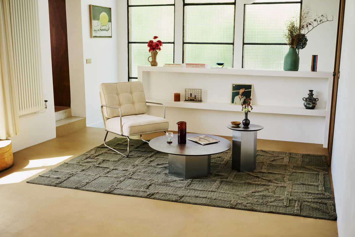 tapis de salon Strato vert kaki vu depuis l'entrée, avec un fauteuil en velours côtelé