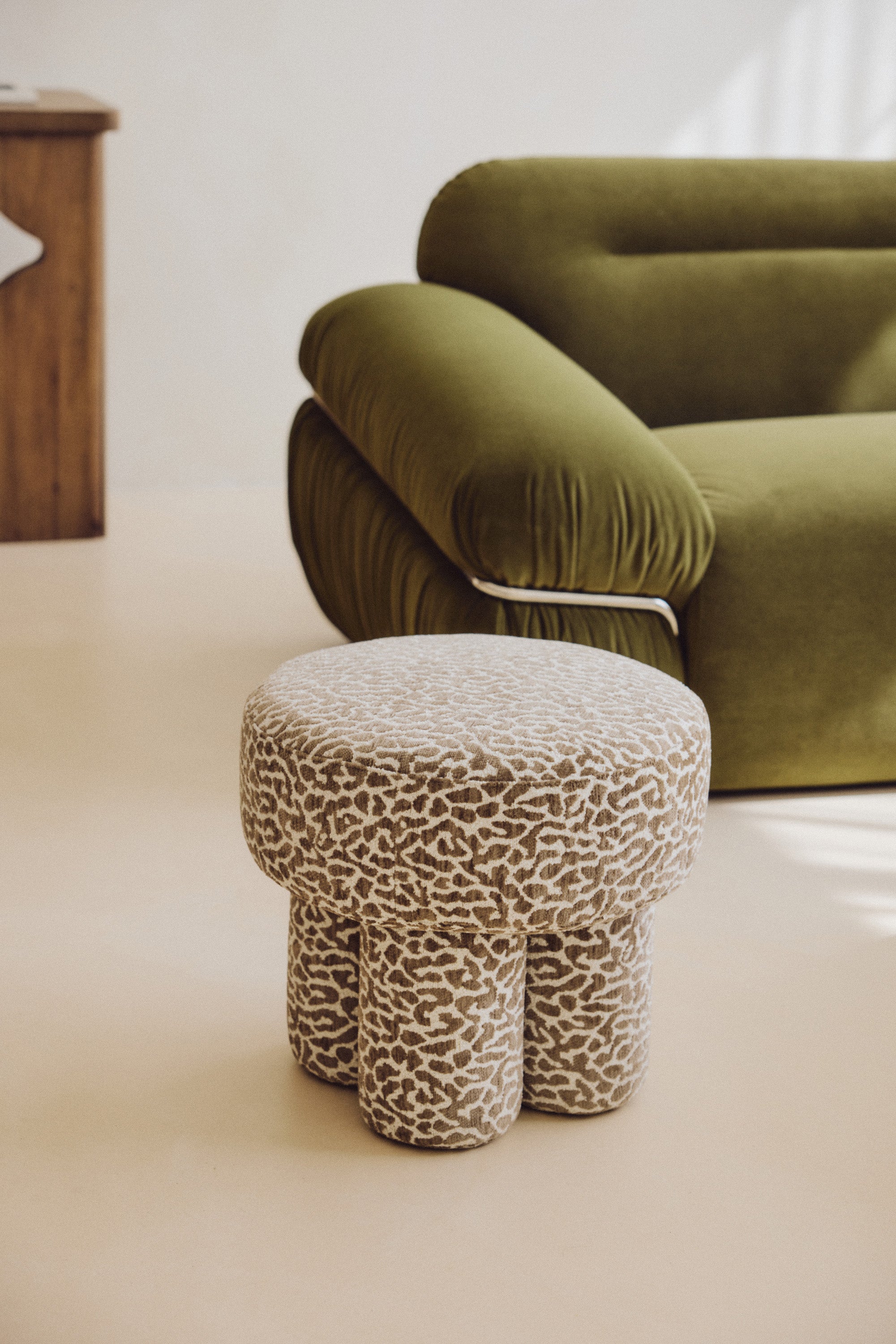 Pouf Corinthe - polyester motif léopard marron - piètement sculpté en gros plan