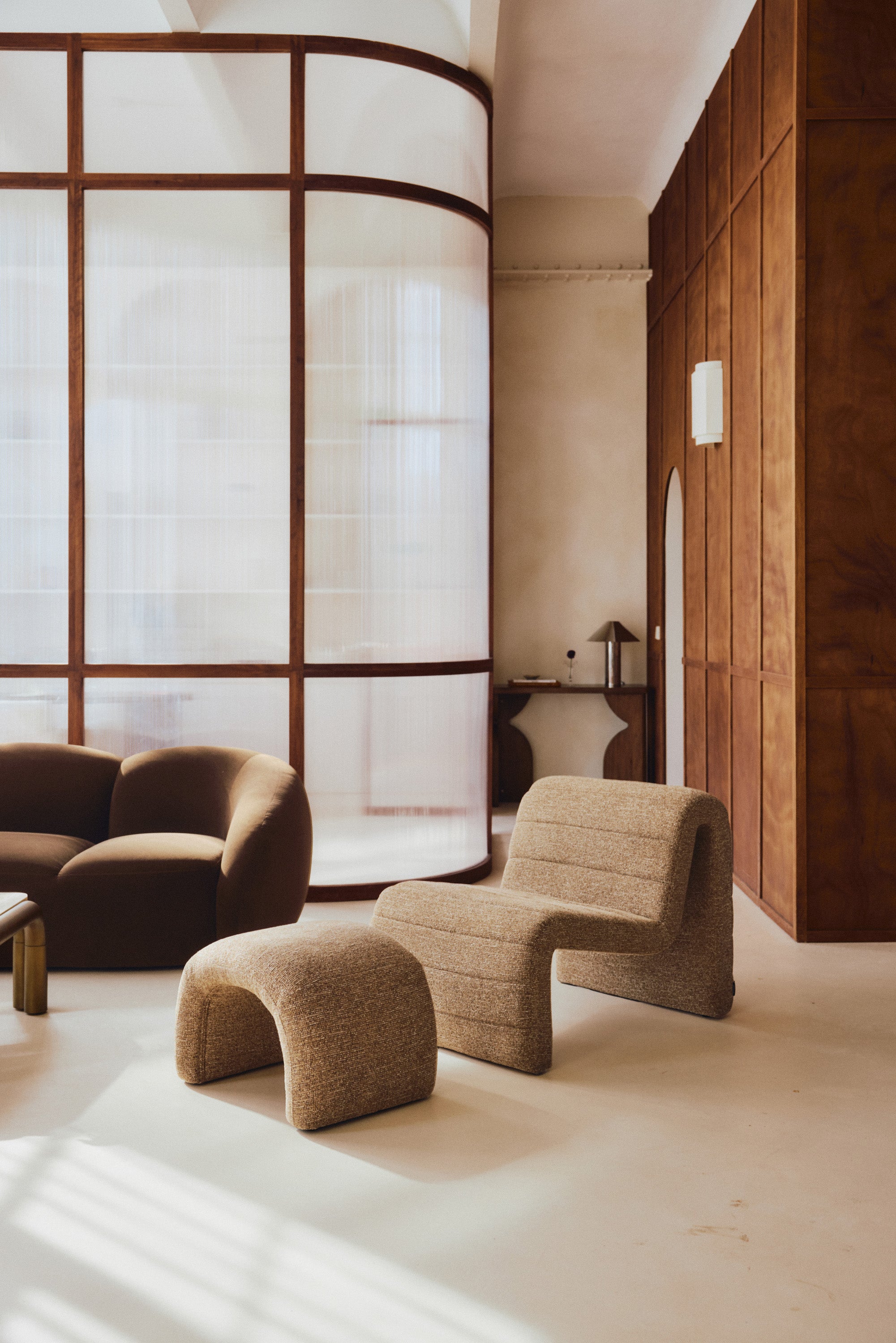 ensemble Flow - fauteuil et pouf tweed marron chêne - vue portrait salon verrière arrondie