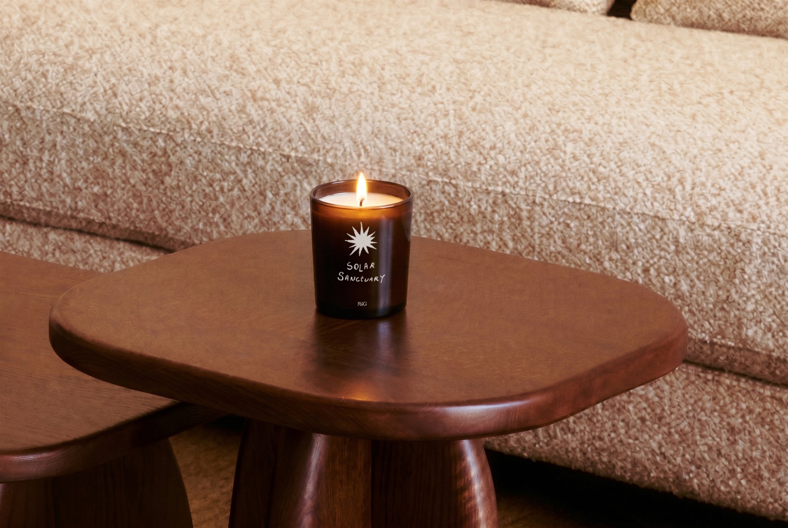bougie Solar Sanctuary NVG x Wiwoos - verre ambré allumé - mise en situation table d'appoint bois massif