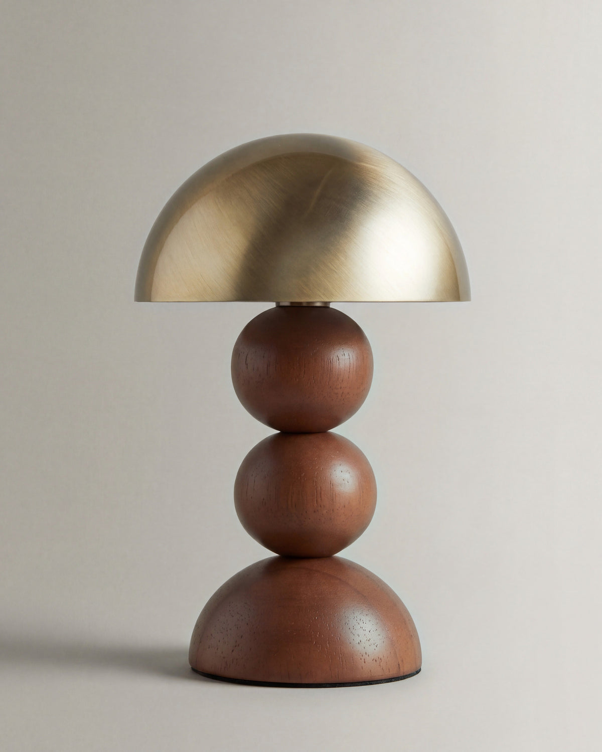 lampe de table GIGI éteinte, dôme en laiton brossé sur un pied en sphères de noyer