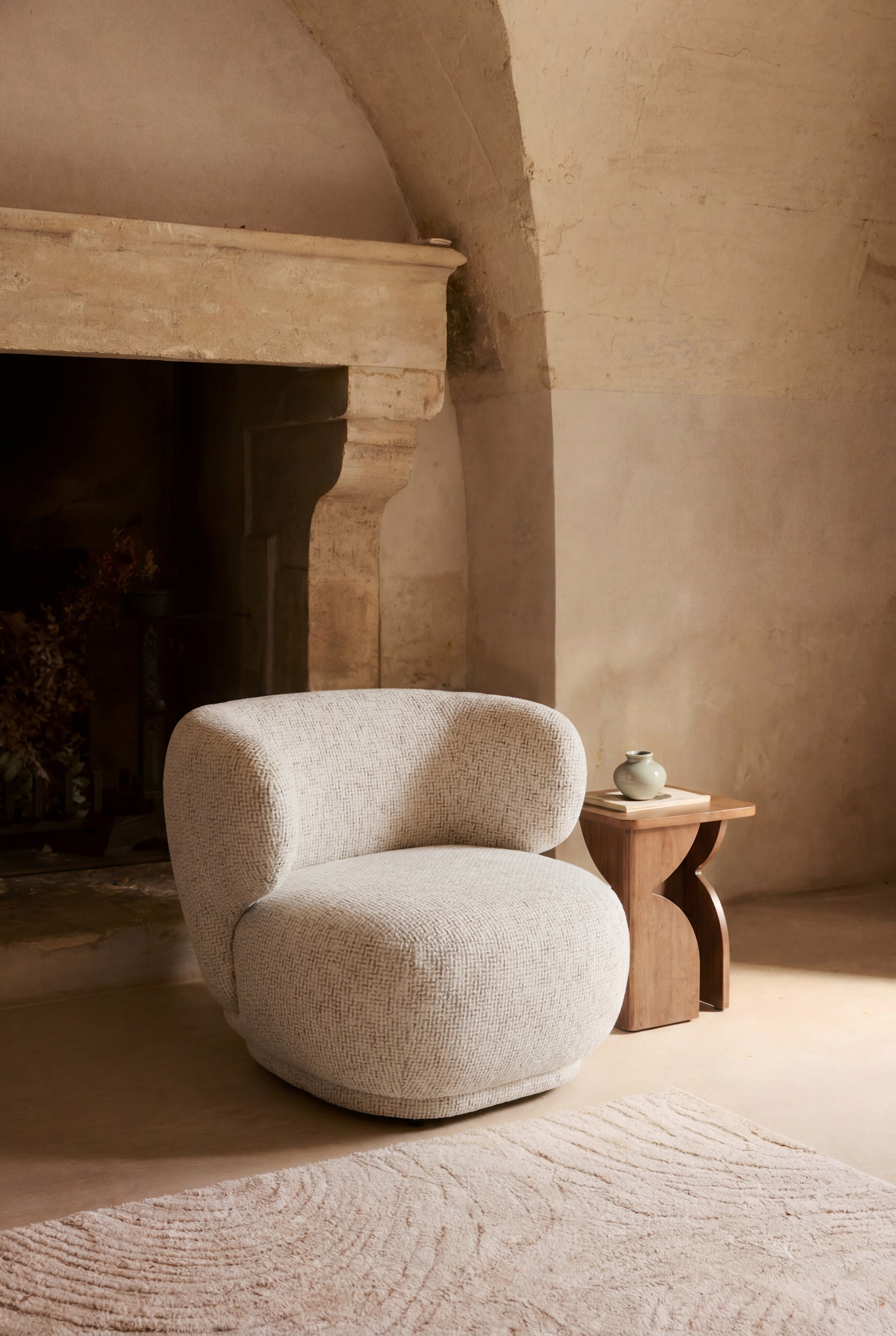 fauteuil Giulia - tweed beige moucheté - vue portrait ambiance cheminée en pierre