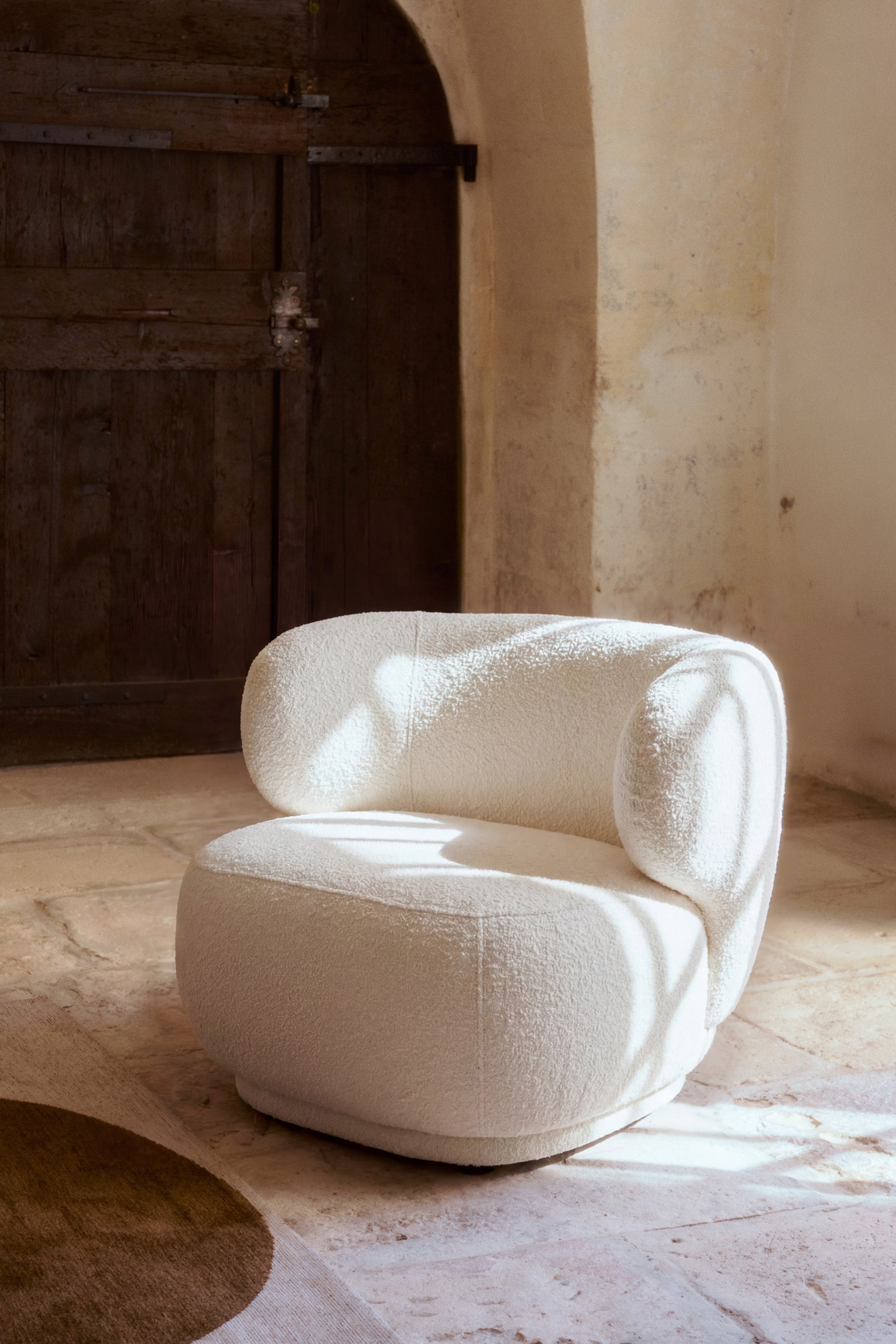 fauteuil Giulia - bouclé écru - vue portrait ambiance voûtes en pierre