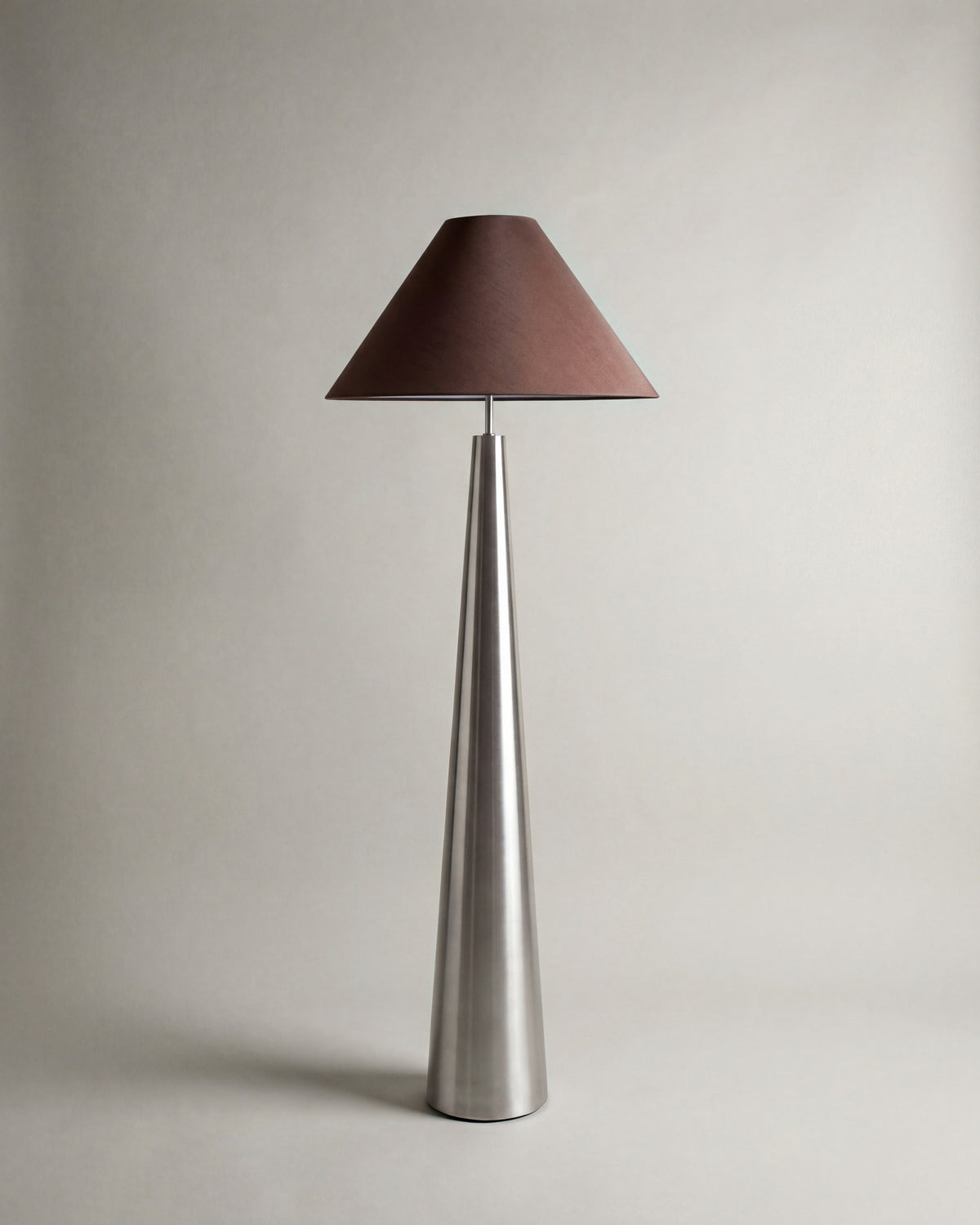 lampadaire KHONE éteint, abat-jour conique brun sur un fût effilé en métal brossé