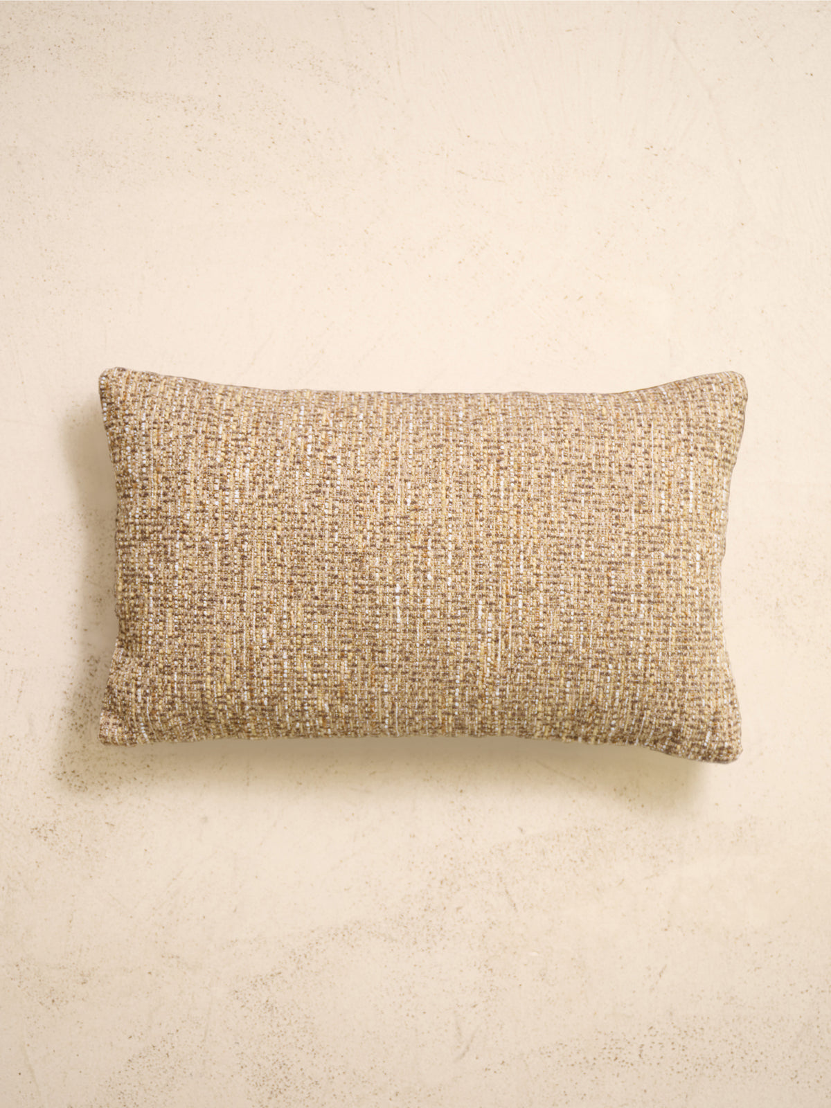 coussin rectangulaire LODGE en tweed marron ristretto, sur un mur en enduit crème