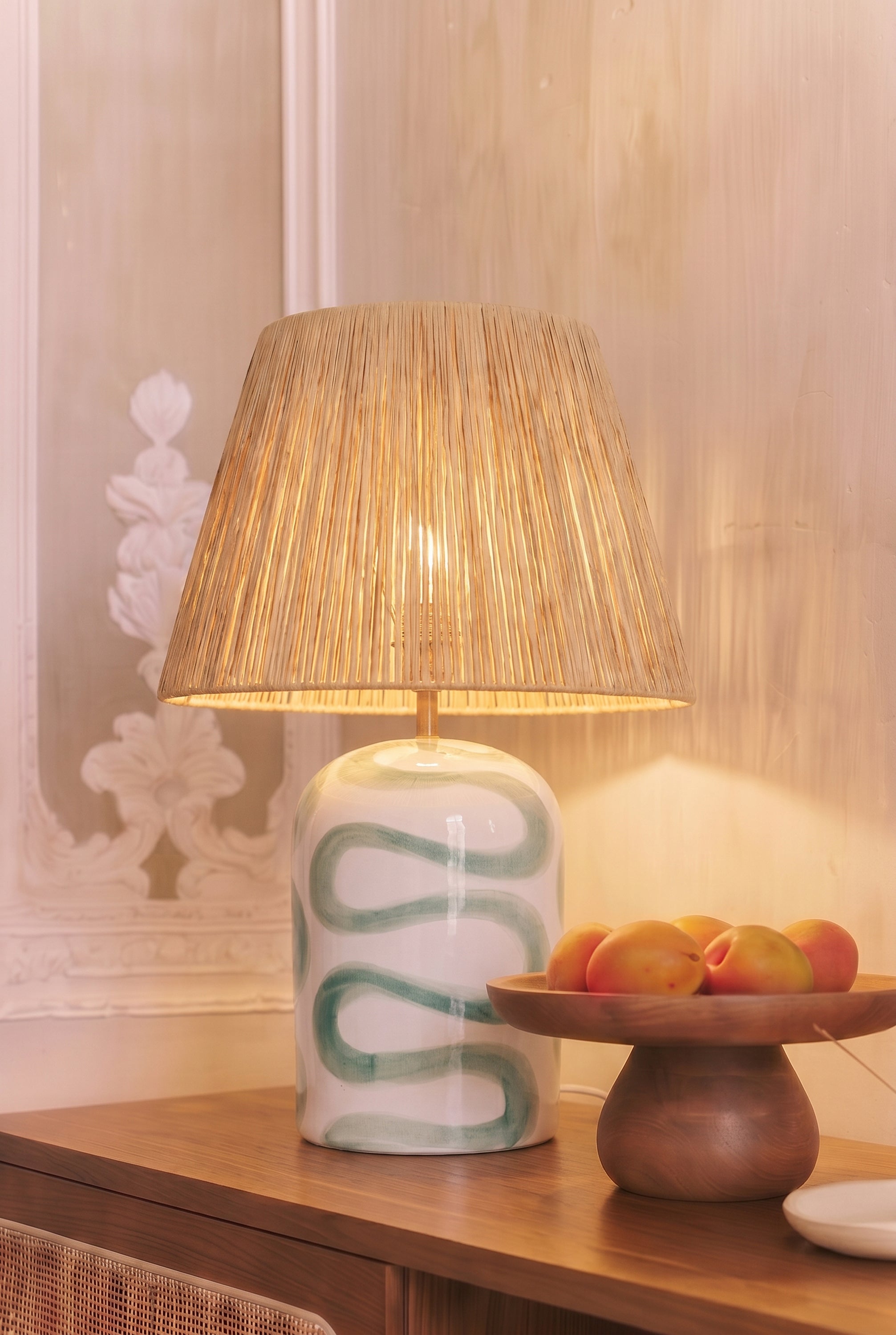 lampe de table Savannah - céramique blanche motif vert et abat-jour raphia - détail allumée