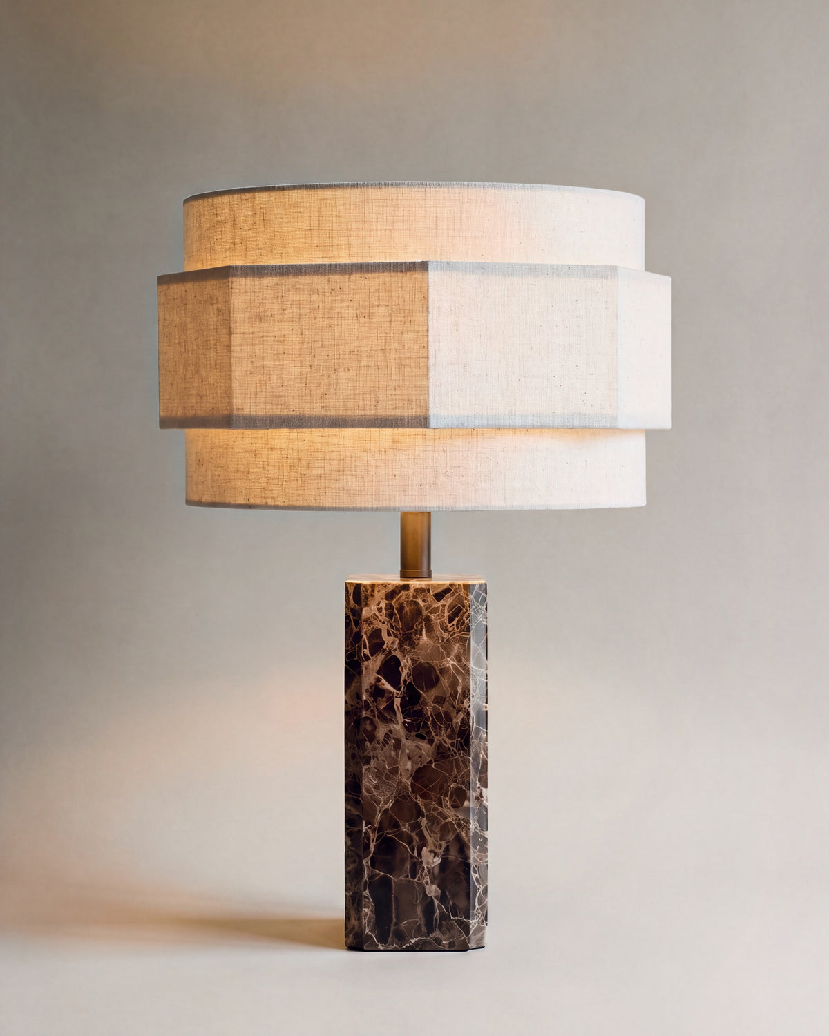 lampe de table MINDY allumée, pied en marbre Dark Emperador et abat-jour à trois étages