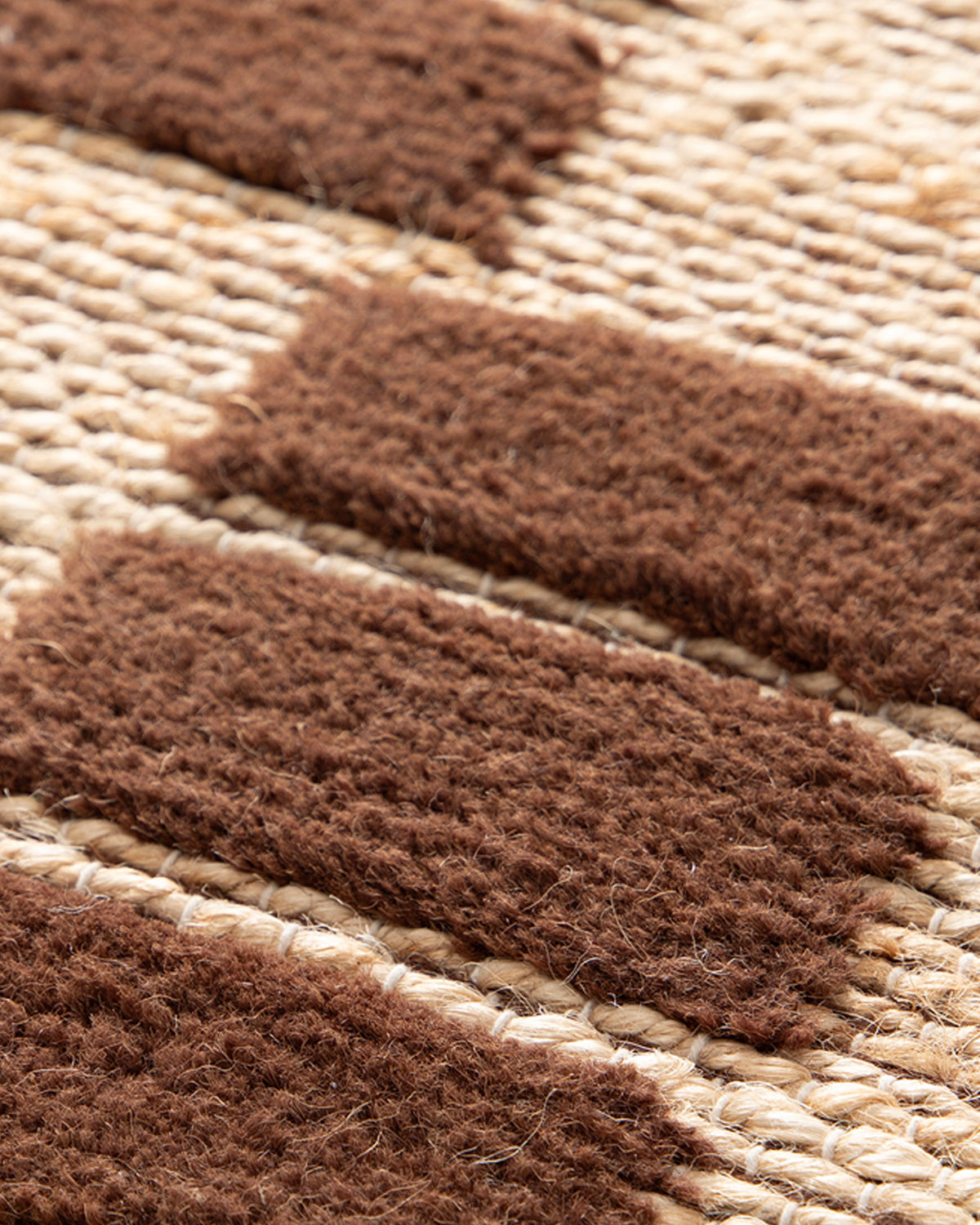 gros plan sur les blocs de laine brune tuftés sur le tissage de jute d'un tapis Saxton