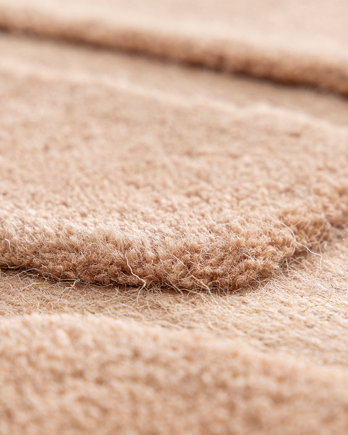 gros plan sur l'épaisseur du velours et le relief des blocs d'un tapis de salon Maze