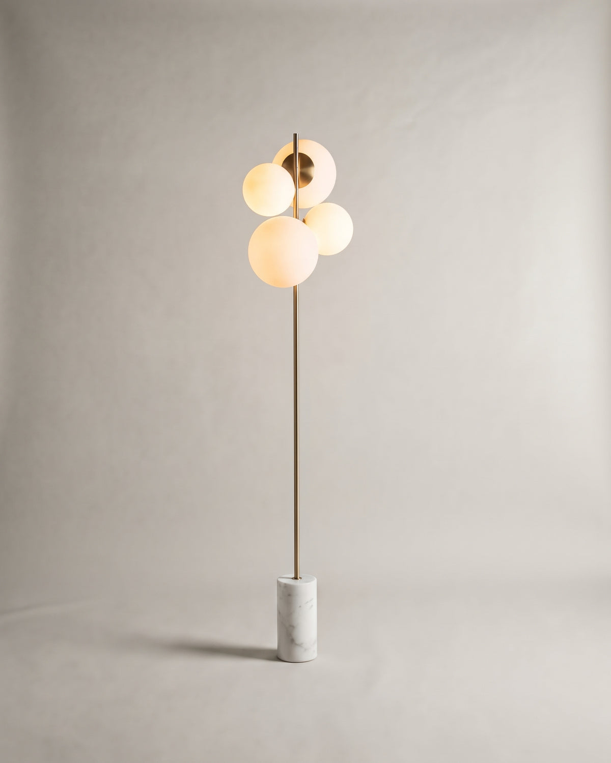 lampadaire SKULL allumé, ses quatre globes opalins diffusent une lumière chaude en grappe