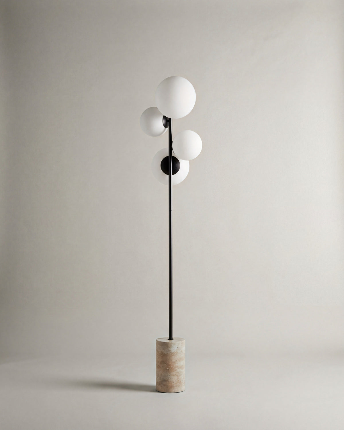 lampadaire SKULL éteint, quatre globes opalins sur tige noire et base en travertin