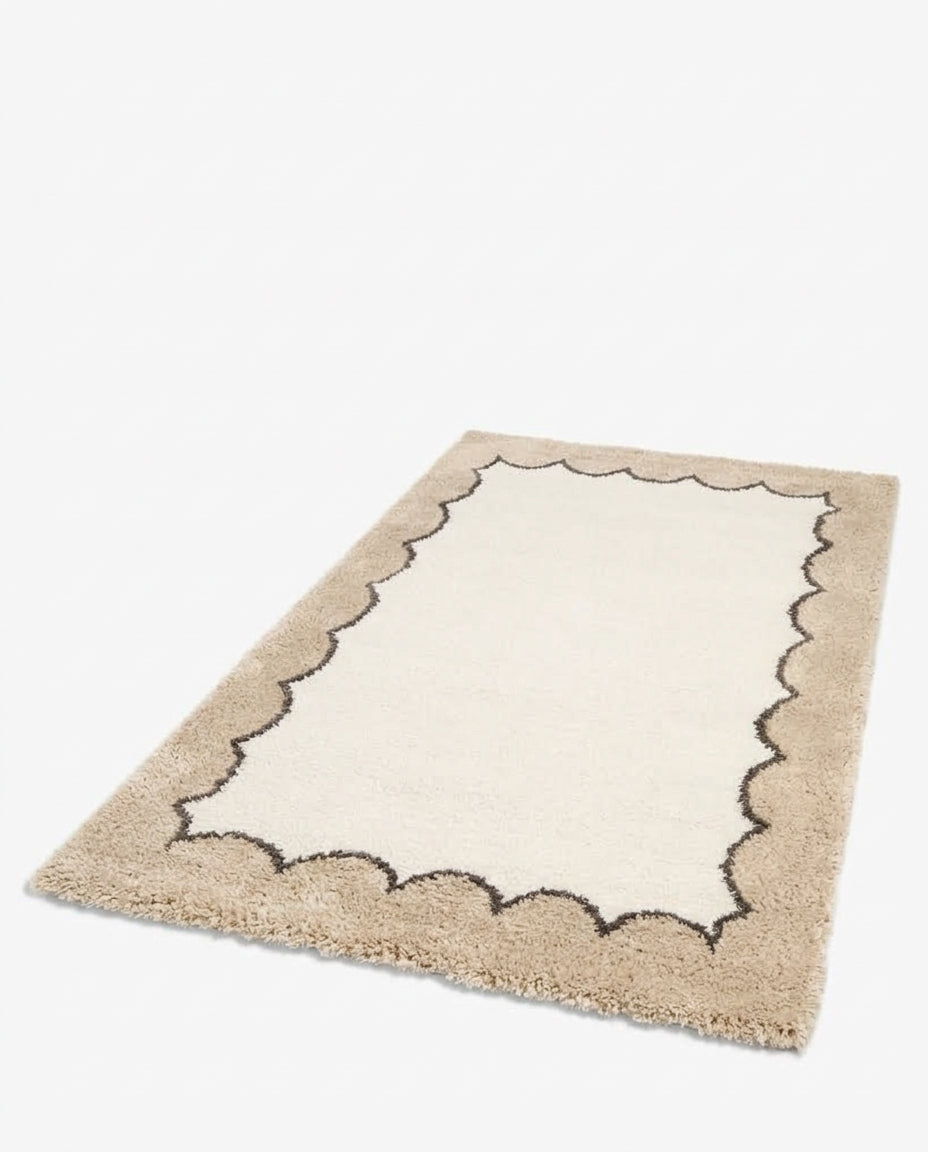 tapis TIDAL écru à bordure beige festonnée, posé à plat et vu en perspective au sol