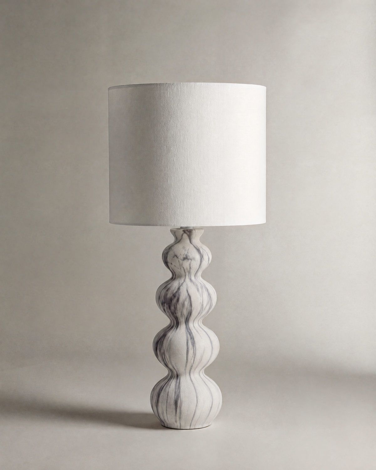 lampe de table NEBULA éteinte, pied ondulé en céramique marbrée et abat-jour écru